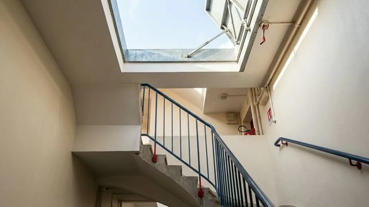 Trappe de désenfumage en toiture d'un immeuble de copropriété vérifiée par un technicien Verifincendie